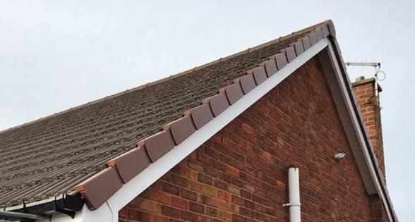 Close-up of a tiled pitched roof showing freshly bedded ridge tiles