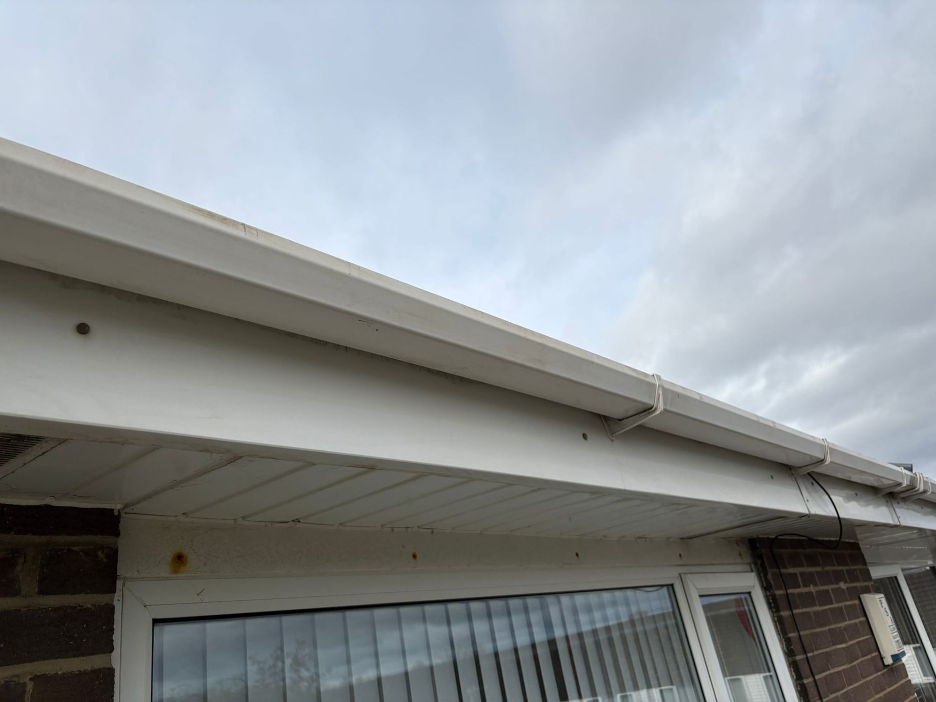 Dirty white uPVC gutters and fascia on a residential property awaiting cleaning