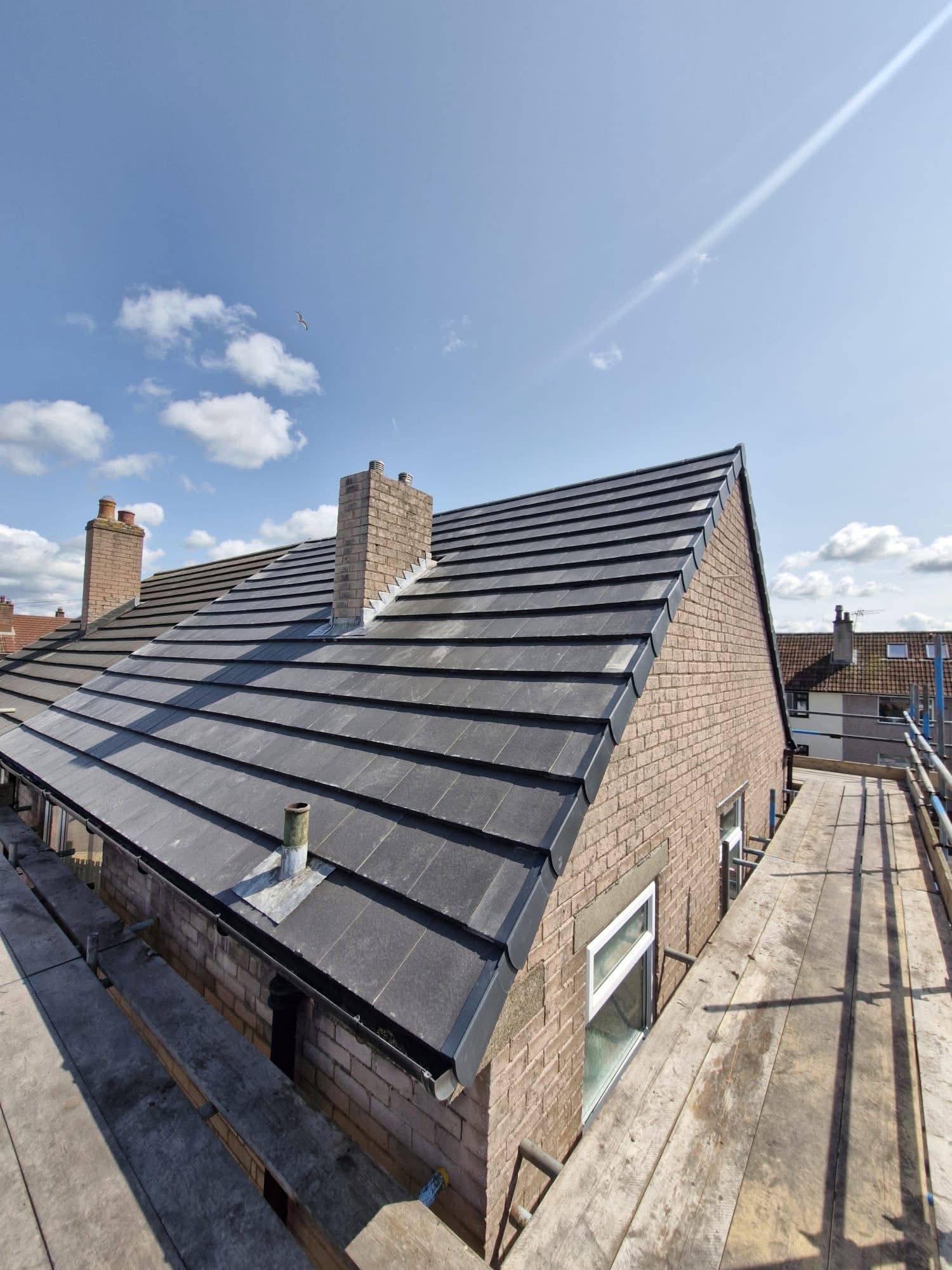 Aerial view of a newly installed tiled pitched roof with chimneys