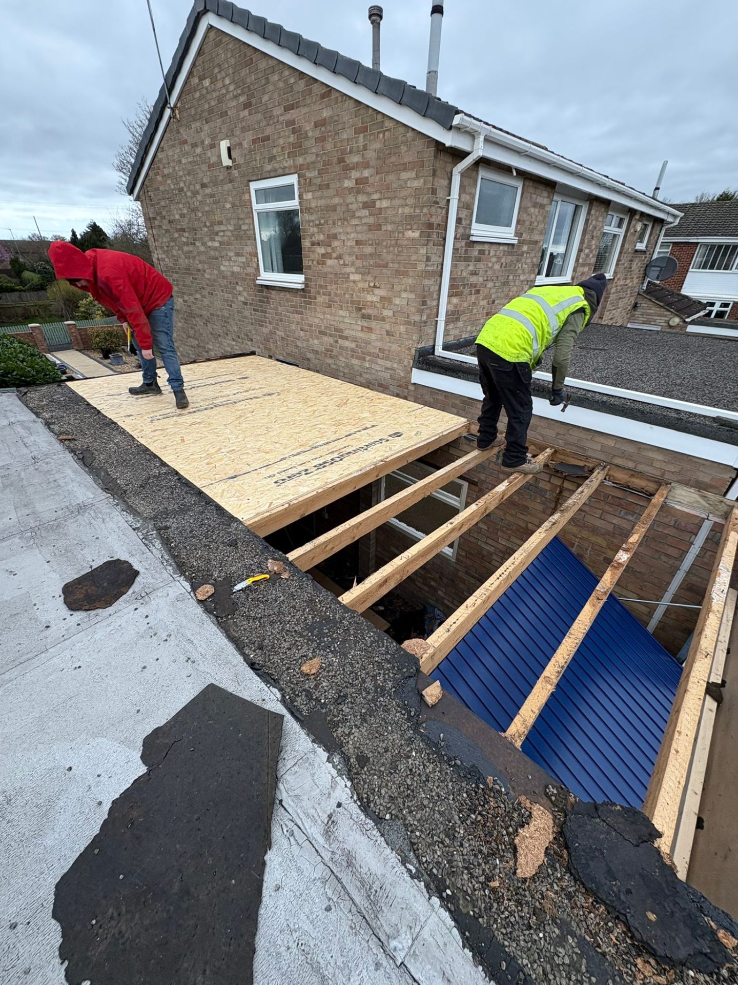 Flat roof extension being built with timber joists and OSB sheathing